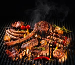 Assorted delicious grilled meat with vegetables over the coals on a Traeger